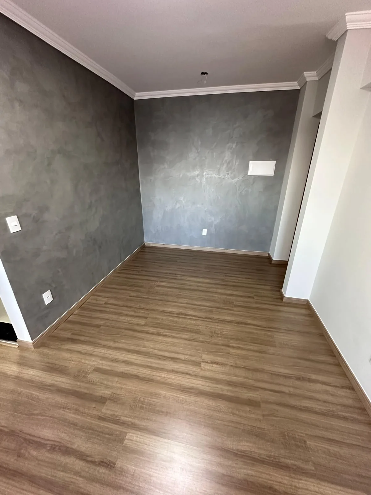 Sala com piso laminado e parede em grafiato, projeto Urban Floor em Hortolândia
